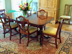 A beautiful oriental rug placed under a dining table and chairs in a dining room by Brandon Oriental Rugs in Furlong, PA.