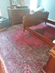A beautifully installed oriental rug with intricate patterns in a bedroom by Pars Rugs Savannah, GA.