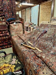 An oriental rug undergoing restoration with repair tools at Bijar Oriental Rugs, a carpet contractor in Atlanta, GA.