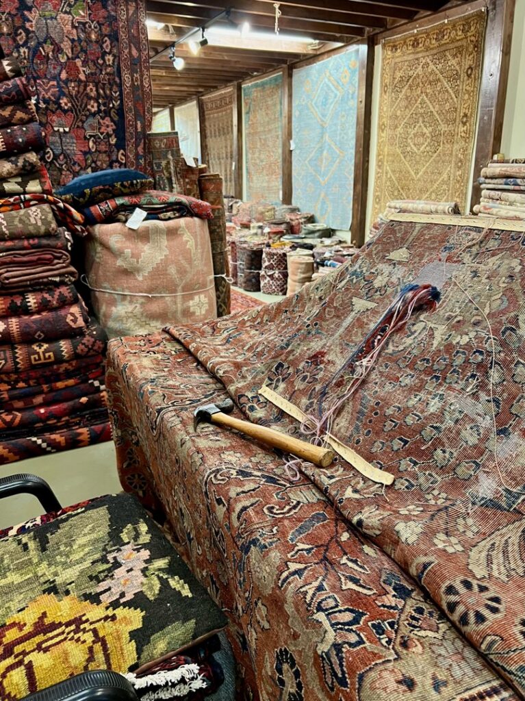 An oriental rug undergoing restoration with repair tools at Bijar Oriental Rugs, a carpet contractor in Atlanta, GA.