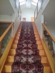 A beautifully installed oriental rug stair runner, showcasing expert carpet contractor work by Borokhim's Oriental Rugs in Madison, WI.