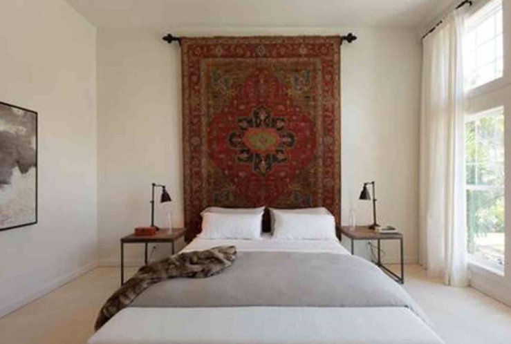 An oriental rug used as a decorative wall hanging in a bedroom, from J and J Oriental Rug Gallery in Alexandria, VA.