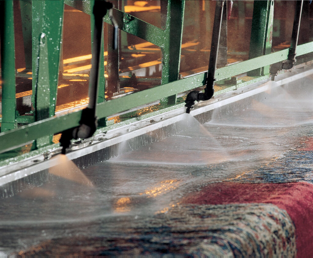 Oriental rugs being professionally cleaned by machinery with water jets at Zakian Rug Cleaning in Philadelphia, PA