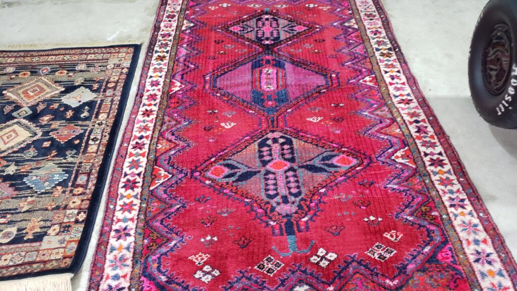 Two colorful oriental rugs laid out on a concrete floor, ready for professional cleaning by Mountain View Carpet Care in Vancouver, WA