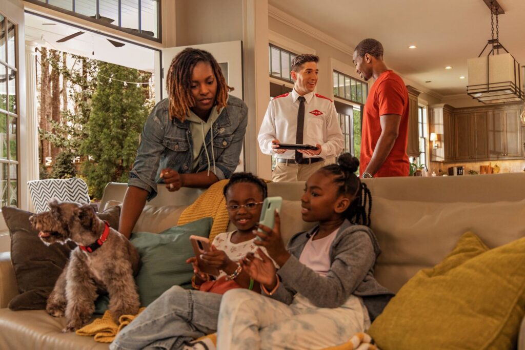 An Orkin Pest Control technician consulting with a family inside their home in Austin, TX.