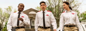 Three Orkin Pest Control technicians in uniform walking towards a job site in Austin, TX.