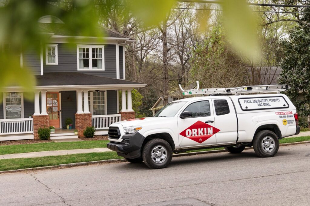 An Orkin Pest Control service truck parked outside a residential home in Jonesboro, AR, ready for a job.
