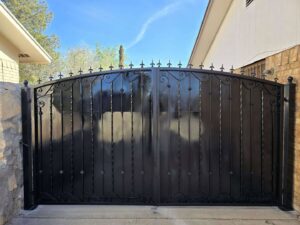 An ornamental black metal driveway gate installed by Iron Man Exteriors in Las Cruces, NM.