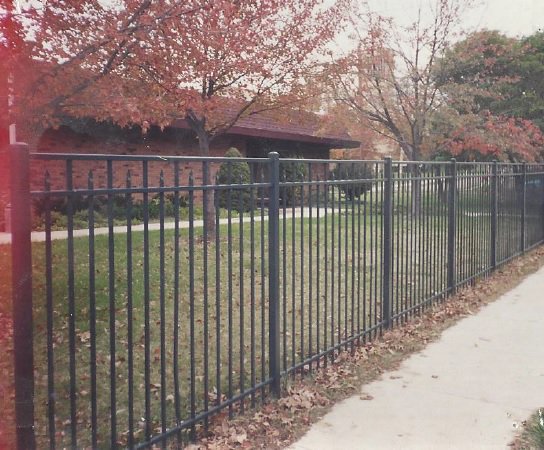 An ornamental black metal fence installed along a sidewalk by James Fencing LLC in Columbia, MO.