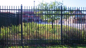 A black ornamental iron fence along a street, showcasing work by Statewide Fencing, Inc. in Racine, WI.