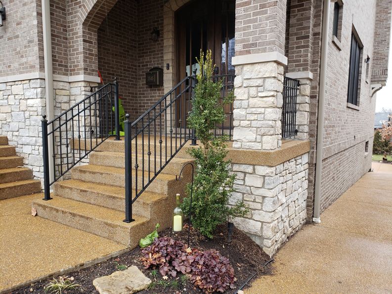 Decorative ornamental iron railings on the front steps and porch of a residential home, installed by Missouri Ornamental Iron and Fence in St Louis, MO.