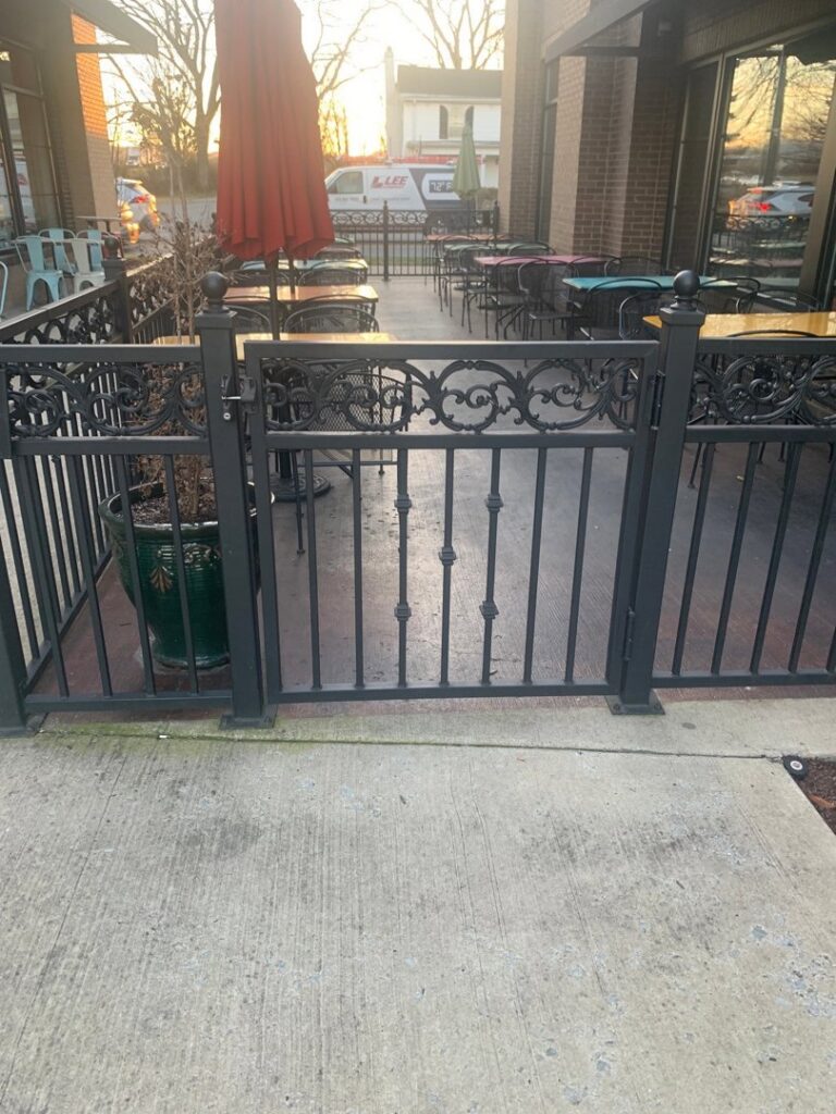 An ornamental metal fence enclosing a commercial patio seating area by America's Fencing in Nashville, TN.