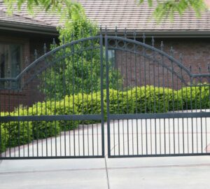A large ornate black metal driveway gate installed by American Fence Company of Norfolk in Grand Island, NE.