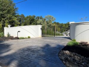 An ornate black metal gate with white stucco walls installed by Gates Contractors in Plymouth, MN.