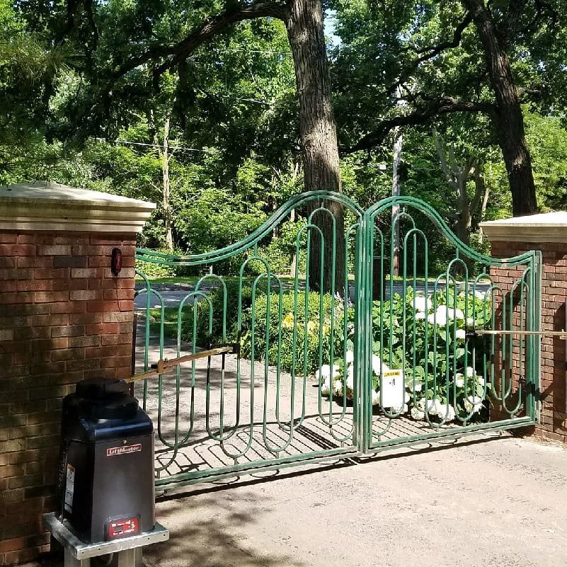 Ornate green automated gate with brick pillars installed by Gate Options in West Chicago, IL