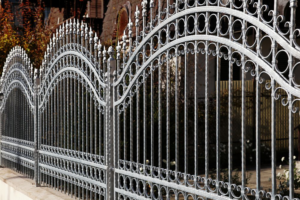 An elegant and ornate grey wrought iron fence with decorative scrollwork by New Bedford Fence in New Bedford, MA.