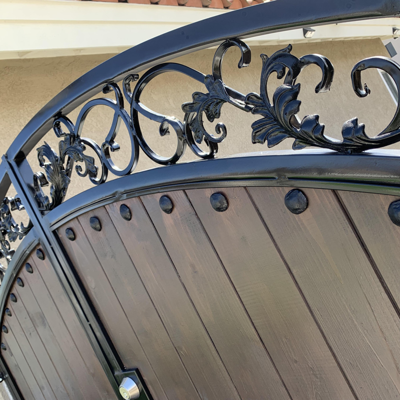 A close-up of an ornate metal and wood gate, showcasing craftsmanship by Portugal's IronWorks in Los Angeles, CA.