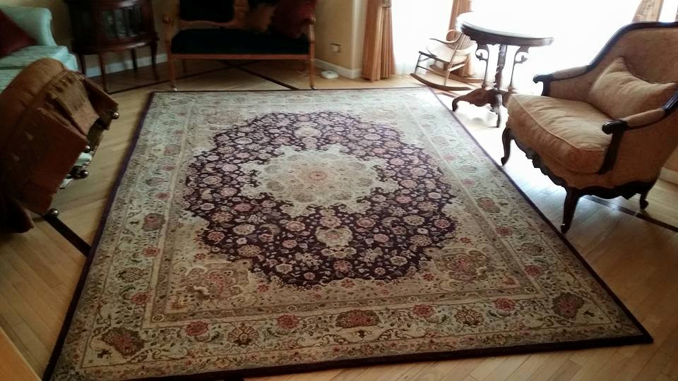 A large, ornate rectangular area rug in a living room, cleaned by 1 Chicago Carpet Cleaner in Plainfield, IL.