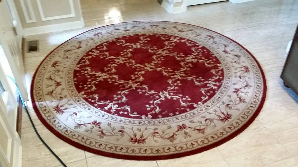 An ornate round red and beige area rug on a tiled floor, cleaned by 1 Chicago Carpet Cleaner in Plainfield, IL.