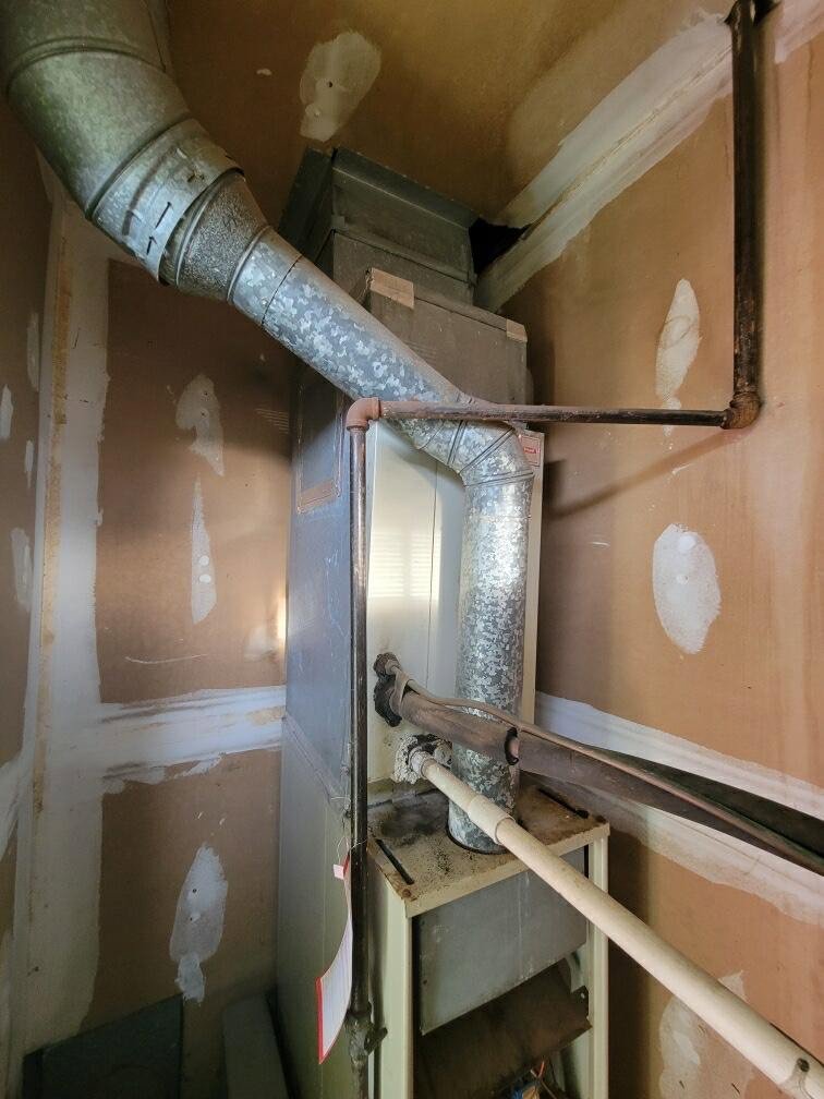 An outdoor AC condenser unit installed on a patio by Riccardi Heating and Air in Toms River, NJ.