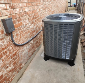 An outdoor air conditioning condenser unit installed by Air Factory Heating & Cooling Company in Oklahoma City, OK.