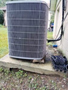An outdoor AC condenser unit installed next to a residential building by Allwaysthere Heating and Cooling in Frederick, MD