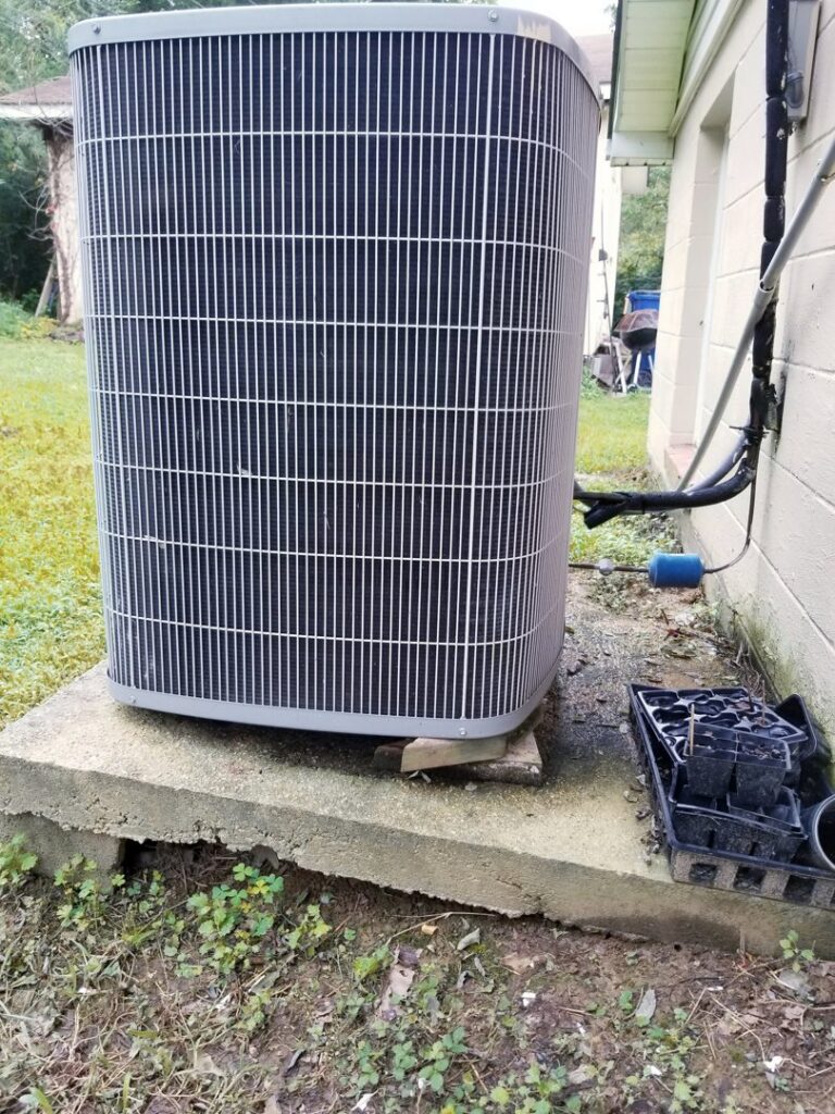 An outdoor AC condenser unit installed next to a residential building by Allwaysthere Heating and Cooling in Frederick, MD