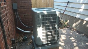 An outdoor Concord air conditioning condenser unit installed next to a brick wall by Naugher Heating and Cooling in Lancaster, PA