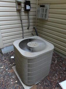 An outdoor AC condenser unit, representing cooling services by Elements Heating & Cooling LLC in Minneapolis, MN.