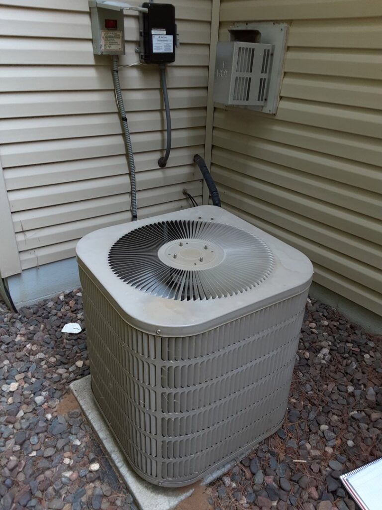 An outdoor AC condenser unit, representing cooling services by Elements Heating & Cooling LLC in Minneapolis, MN.