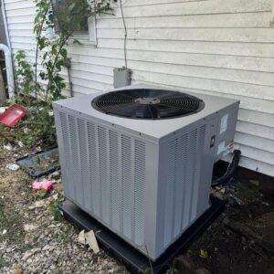 An outdoor AC condenser unit installed next to a house, serviced by Hodges Heating & Cooling in Owensboro, KY.