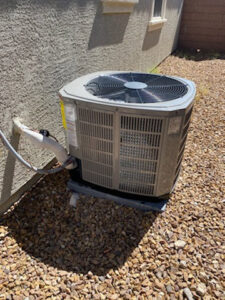 An outdoor air conditioning condenser unit installed on a gravel bed by Ace A/C & Heating in Henderson, NV.