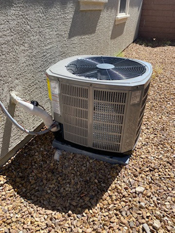 An outdoor air conditioning condenser unit installed on a gravel bed by Ace A/C & Heating in Henderson, NV.