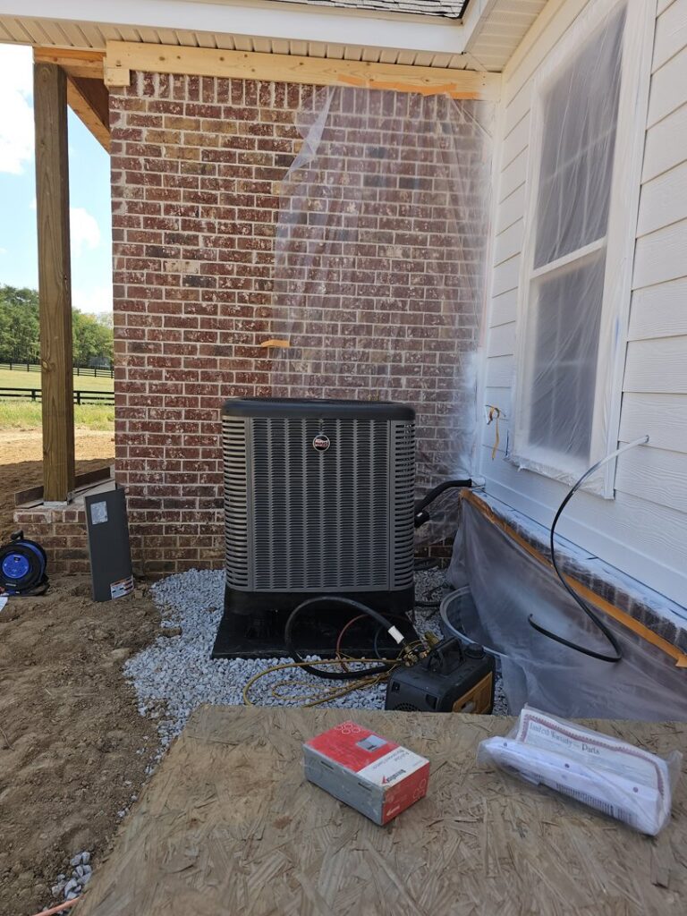 An outdoor AC condenser unit installed next to a brick house by Aces of Air Inc. in Georgetown, KY.