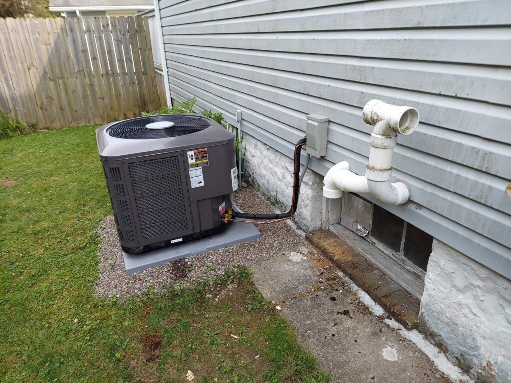 An outdoor air conditioning condenser unit installed next to a residential home by Allied Heating and Air Conditioning in Port Richey, FL.