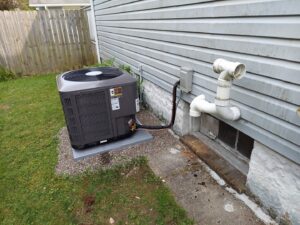 An outdoor air conditioning condenser unit installed next to a residential home by Allied Heating and Air Conditioning in Port Richey, FL.