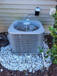 An outdoor AC condenser unit installed next to a home by Comfort Hounds Heating & Cooling in Raleigh, NC.