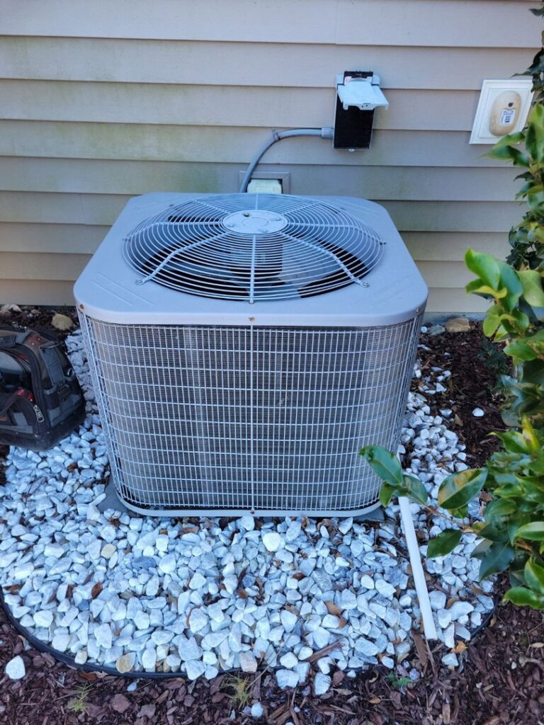 An outdoor AC condenser unit installed next to a home by Comfort Hounds Heating & Cooling in Raleigh, NC.