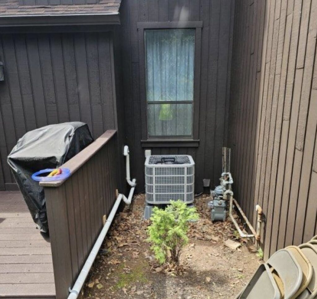 Outdoor air conditioning condenser unit installed next to a residential building by NewEra Mechanical LLC in New Britain, CT