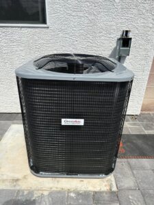 An outdoor AC condenser unit installed next to a residential building by Honest AC Experts in Las Vegas, NV
