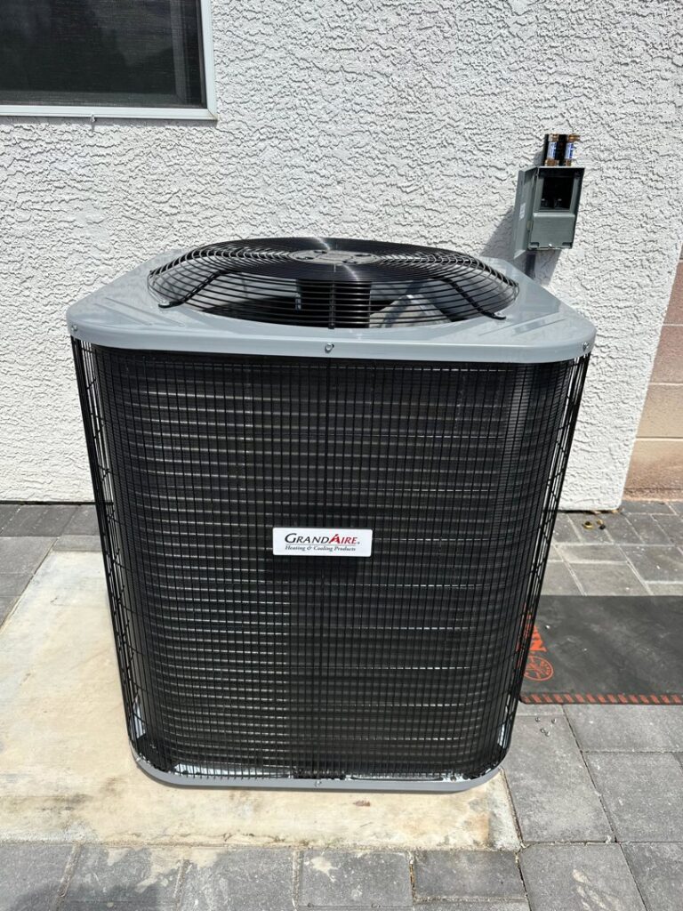 An outdoor AC condenser unit installed next to a residential building by Honest AC Experts in Las Vegas, NV