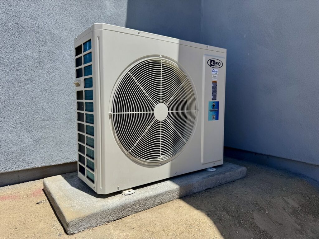 An outdoor AC condenser unit installed on a concrete pad by Mi Amigo HVAC in Surprise, AZ