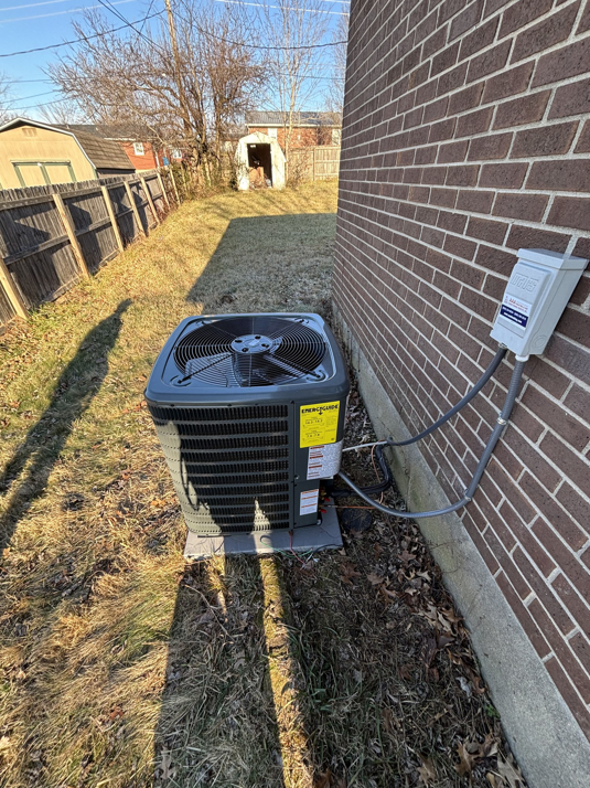 An outdoor AC condenser unit next to a brick residential building, installed by AAA Heating & Air Conditioning Service Inc. in Lexington, KY.