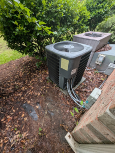 An outdoor AC condenser unit installed next to a residential home by Prestige Heating Cooling & Appliances Llc in Sumter, SC.