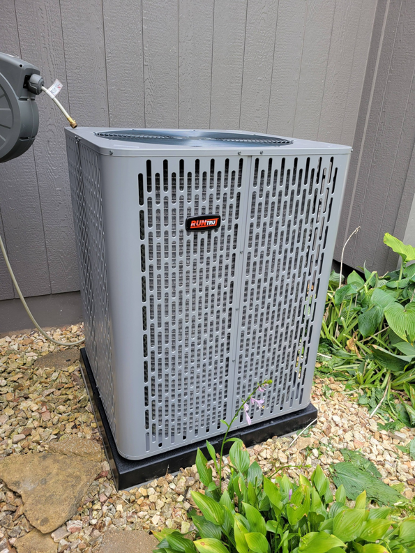 An outdoor RunTru AC condenser unit installed by ESR Heating, Cooling and Refrigeration in Raymore, MO.