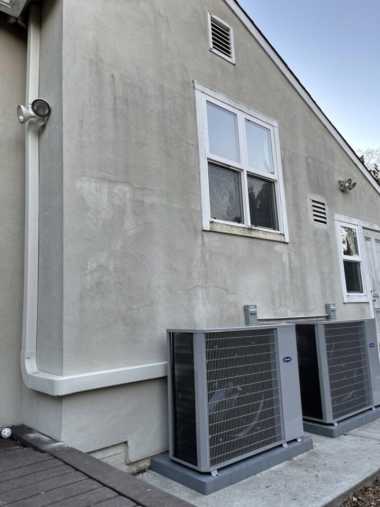 Two Carrier outdoor AC condenser units installed next to a home by Blue Collar HVAC in Henderson, NV.