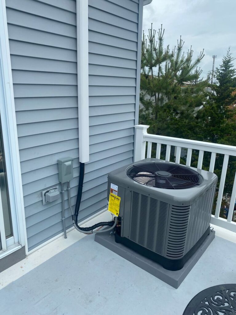 An outdoor AC unit installed on a residential balcony by Tom's Heating & Air Conditioning LLC in Lacey Township, NJ.