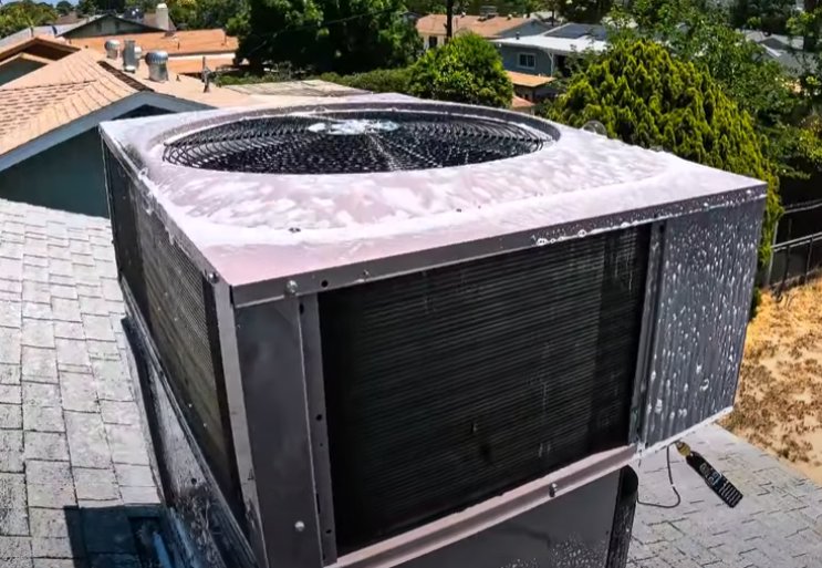 An outdoor AC unit being cleaned with foam for maintenance by RESTQ HVAC Repairs & Services in Rockville, MD.