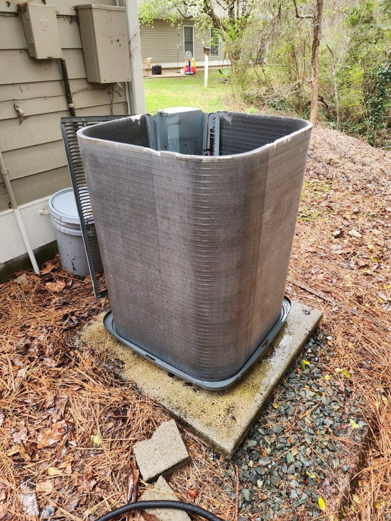 An outdoor air conditioning unit with its casing removed, exposing the coils for service by Sizemore Heating & Air, LLC in Chapel Hill, NC