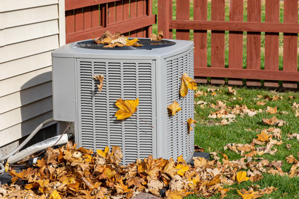 An outdoor AC unit covered in leaves, indicating a need for HVAC maintenance from TC Heating and Air Conditioning LLC in Elgin, IL.